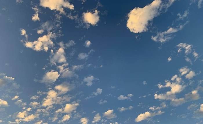 Open blue sky scattered with soft clouds